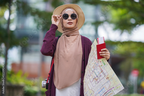 Portrait of beautiful young solo Muslim traveler exploring the city