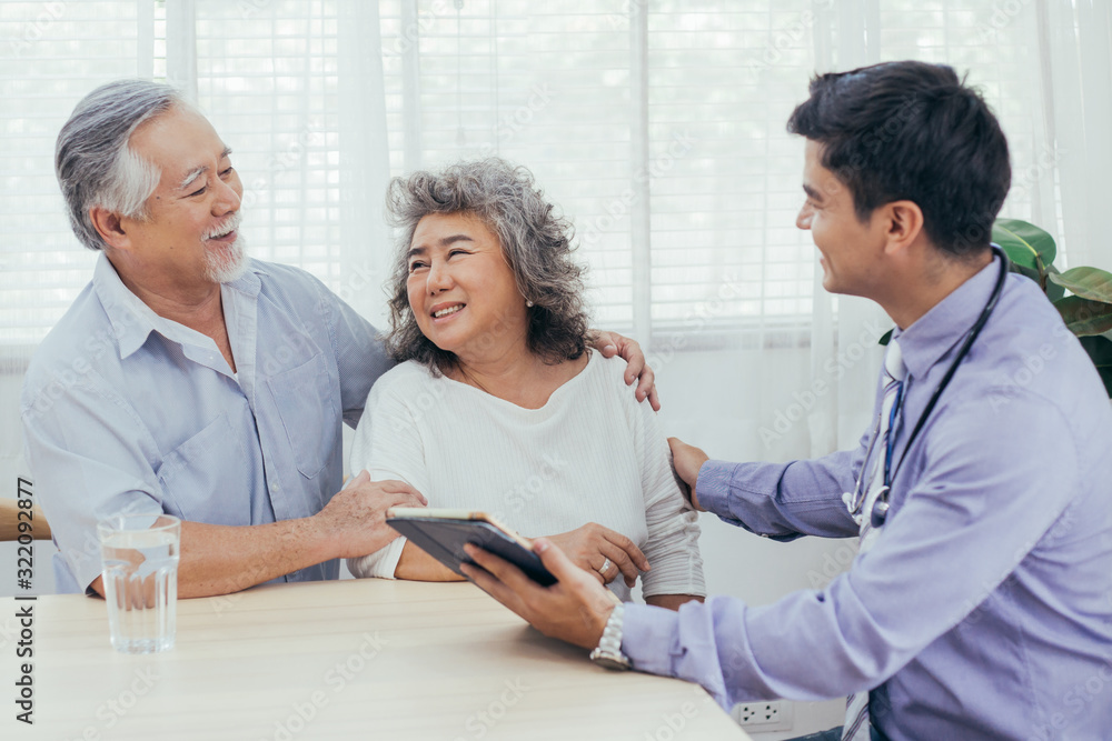 Asian doctor using tablet discussing test result and diagnosis in positive, Happy senior couple excited and receiving good news, old woman smiling to her elderly husband, Healthcare and Insurance Asian doctor using tablet discussing test result and diagnosis in positive, Happy senior couple excited and receiving good news, old woman smiling to her elderly husband, Healthcare and Insurance