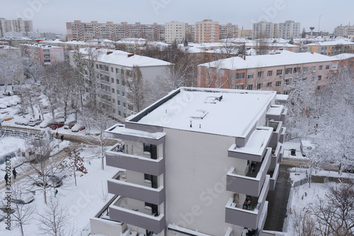 Obraz na płótnie Bucharest, Romania - February 6, 2020: Winter scene in a residential area with new and old apartment block buildings, with snow covered roofs, in Bucharest, Romania, after a mild snow. w salonie