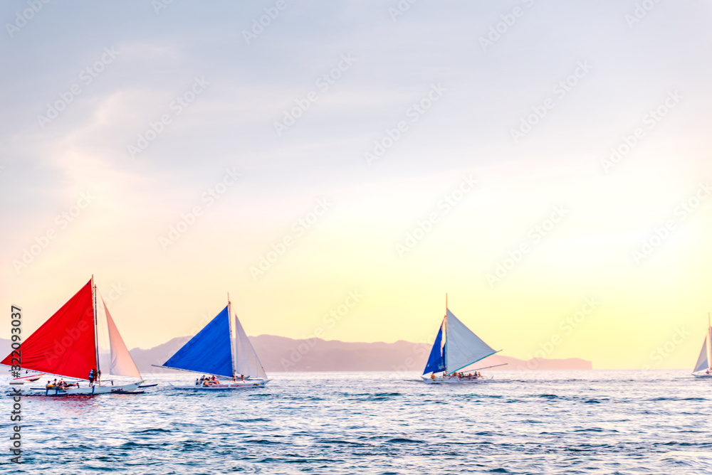 Boracay Island, Aklan, Philippines - Visitors enjoy sunset in a traditional Paraw boat powered by wind at Sunset. Circa January 2020