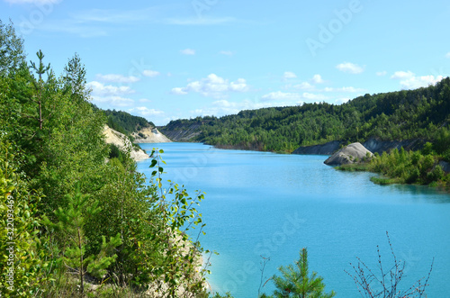 Chalk quarry artifical lakes in Belarus at Krasnoselsky village. Turquoise background of the clear ocean water in summer tropical season. Technogenic open pit for tourism © MaxSafaniuk