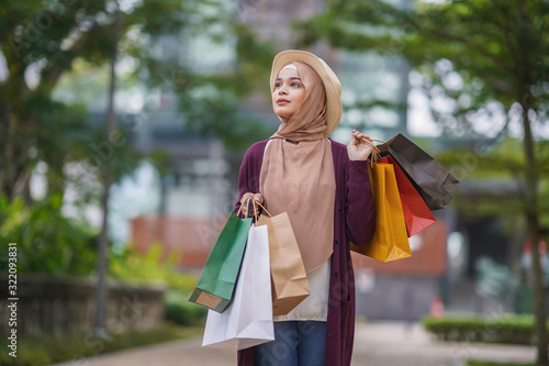 Portrait of beautiful young solo Muslim traveler exploring the city and shopping