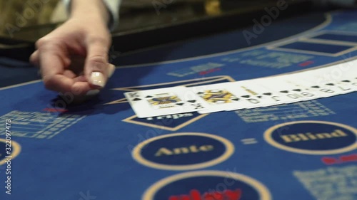 Dealer beautifully lays out cards on the card table in the casino