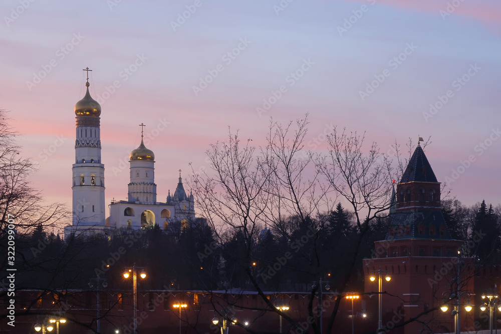 Kremlin tower and Ivan the Great bell tower after sunset. Fragment of architectural ensemble of the Moscow Kremlin.