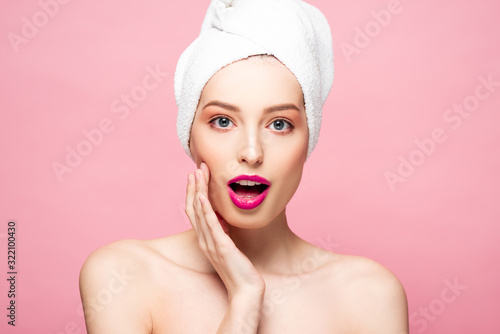 surprised and naked woman in white towel isolated on pink