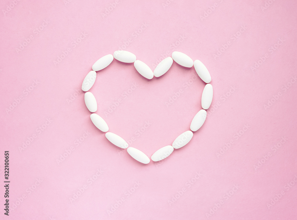 Heart shape made from pills for therapy, concept of treatment and health care on pink