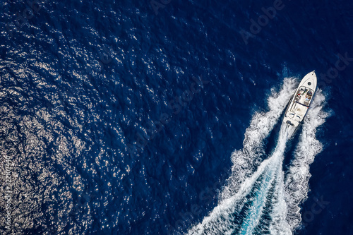 Ein Motorboot in schneller Fahrt über blauem Ozean mit Textfreiraum © moofushi
