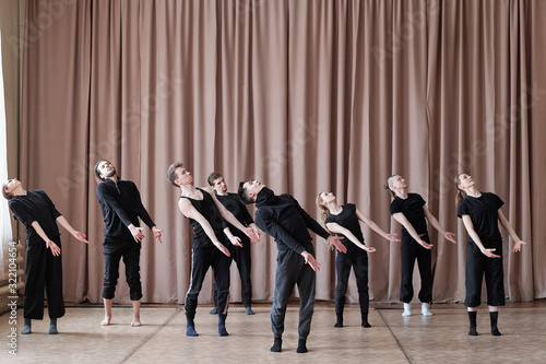 Fotografie Horizontal shot of professional dancers wearing black outfit rehearsing their ne