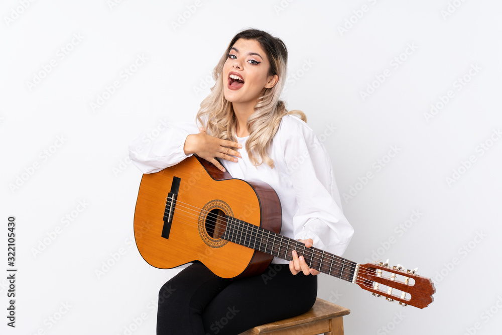 Teenager girl with guitar over isolated white background with surprise facial expression Teenager girl with guitar over isolated white background with surprise facial expression