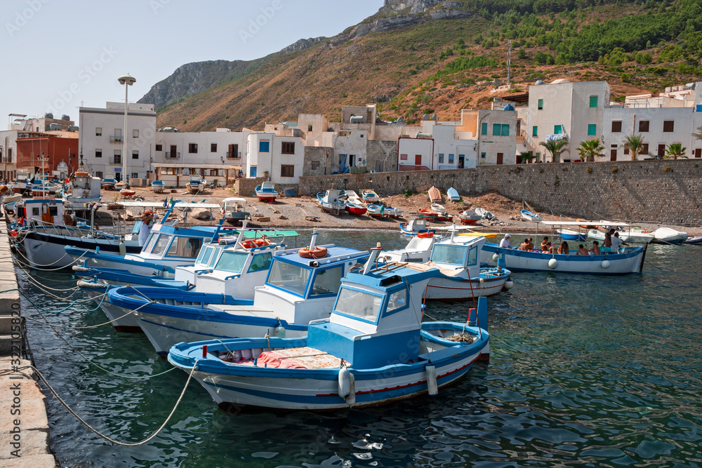 Some fishing boats anchored on the shore in the small port of the island of Marettimo, in the Egadi islands in Sicily, Italy.