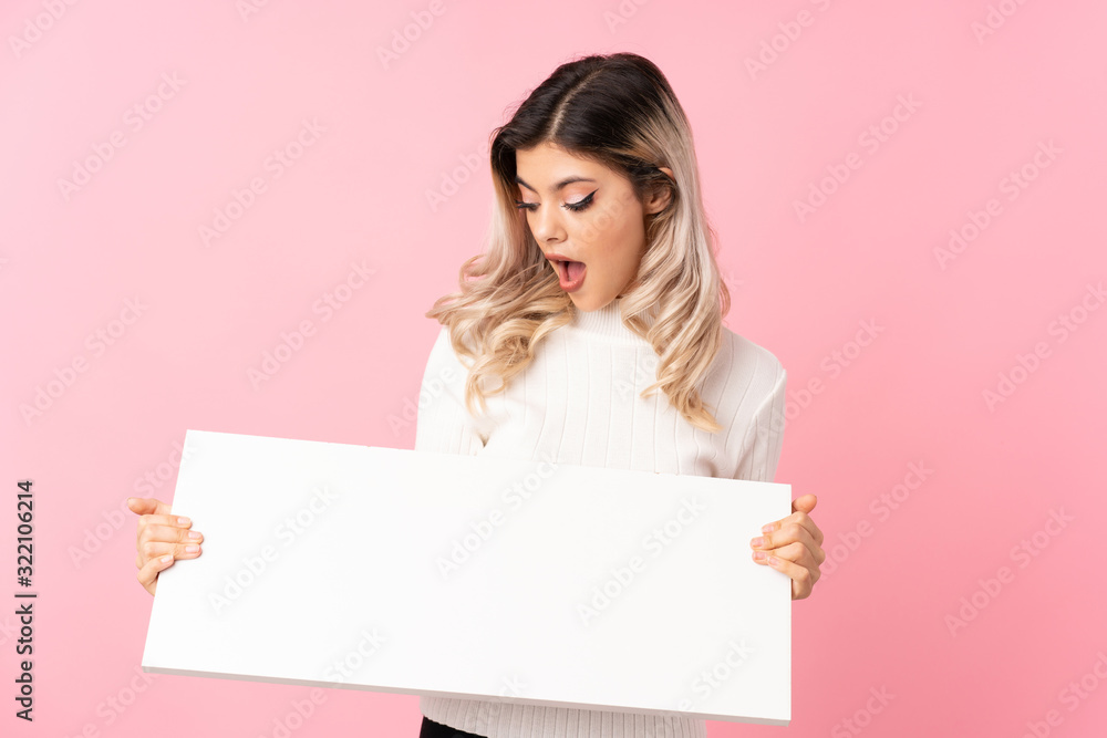 Teenager girl over isolated pink background holding an empty white placard for insert a concept Teenager girl over isolated pink background holding an empty white placard for insert a concept