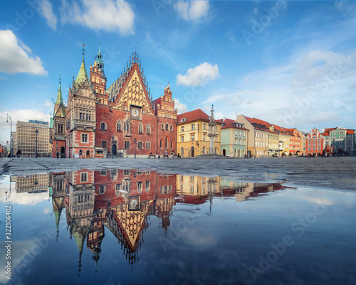 Wroclaw, Poland. Historic Town Hall building - the main architectural landmark of the city reflecting in puddle on Rynek square