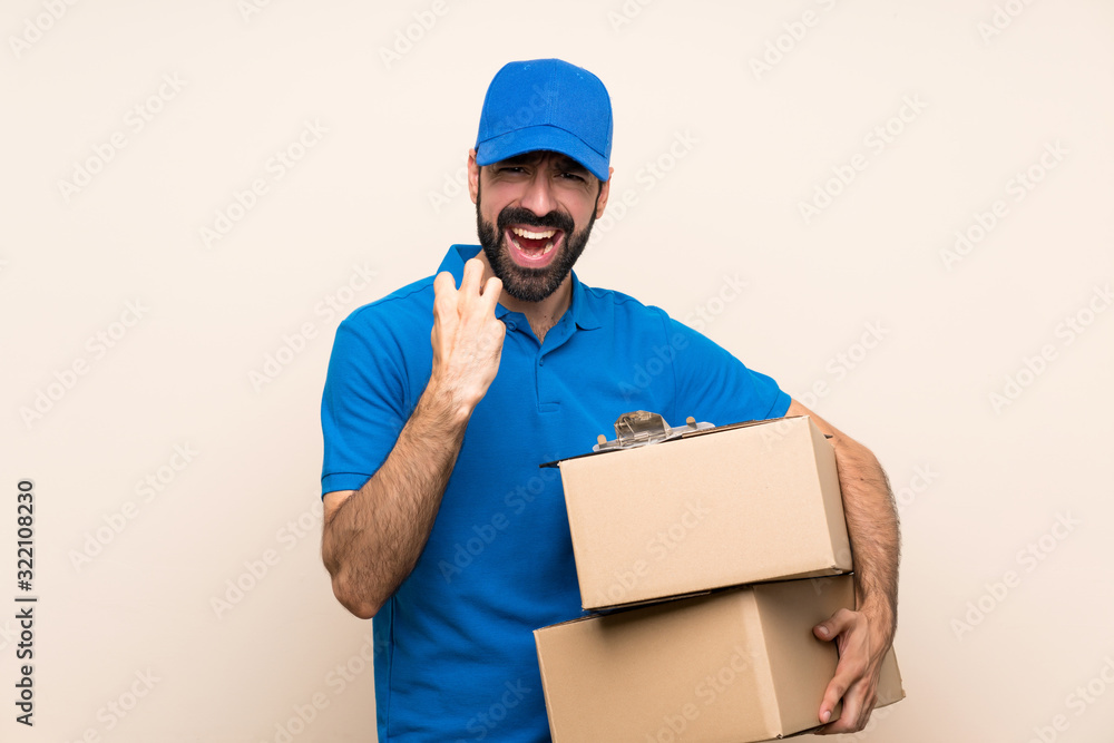 Delivery man with beard over isolated background frustrated by a bad situation
