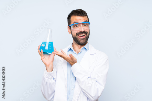 Happy Young scientific holding laboratory flask over isolated background