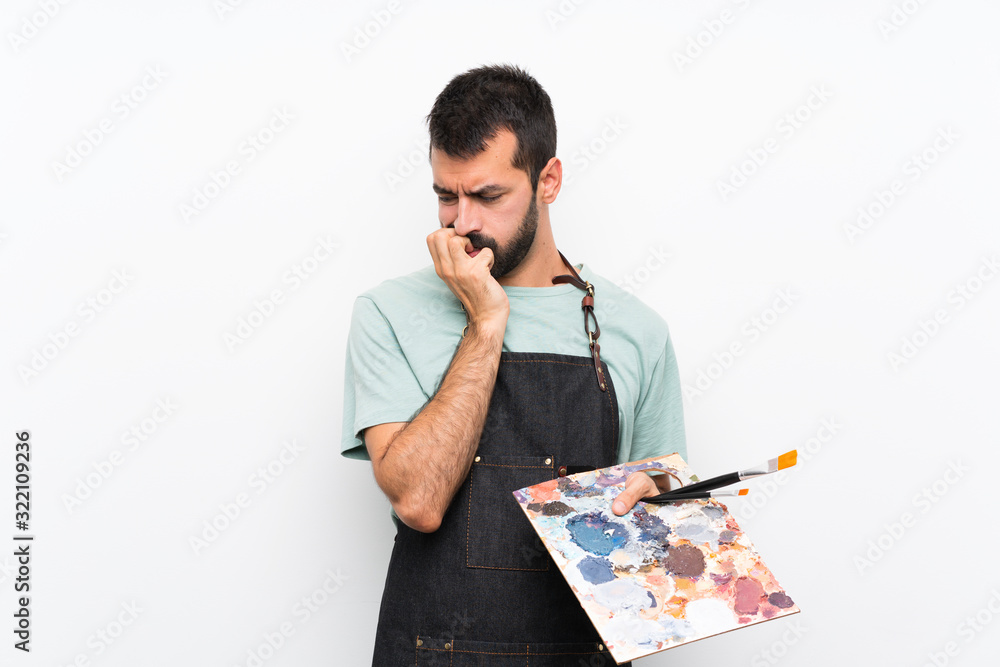 Young artist man holding a palette over isolated background having doubts Young artist man holding a palette over isolated background having doubts