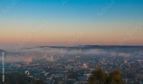 Dawn over the city in the fog © MaksimM