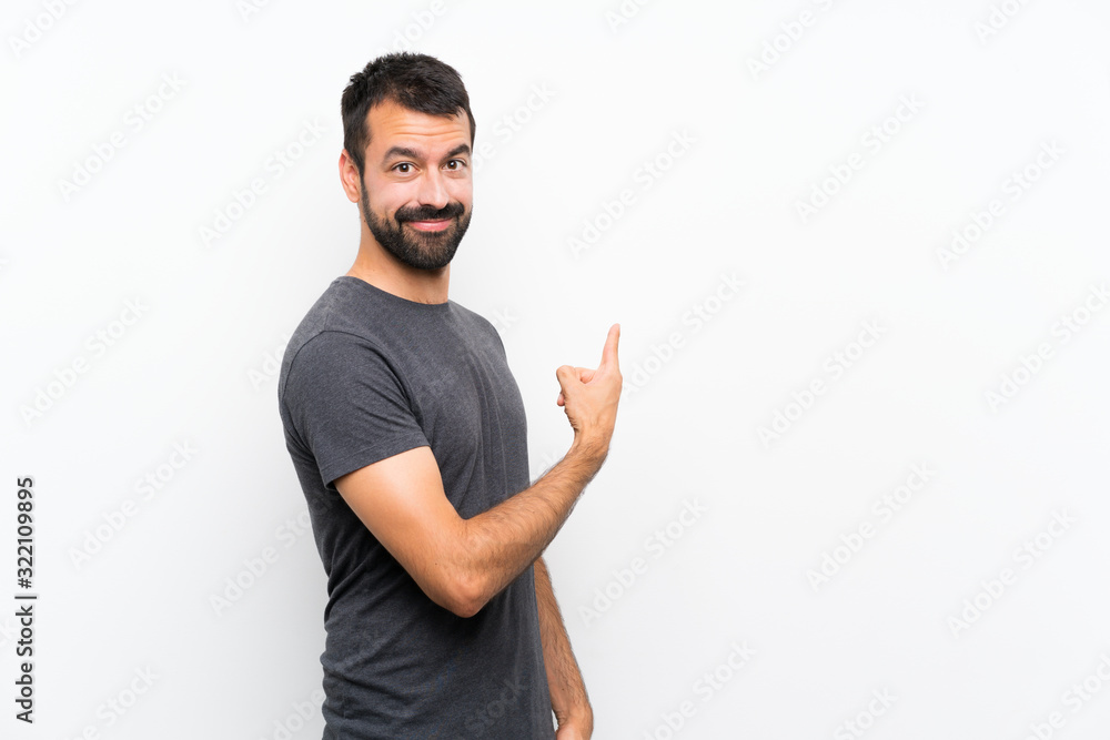Young handsome man over isolated white background pointing back Young handsome man over isolated white background pointing back