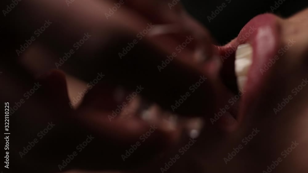 A guy holds an ice cube on the lips of a girl. Close-up. Passion in family relationships. A guy holds an ice cube on the lips of a girl. Close-up. Passion in family relationships.