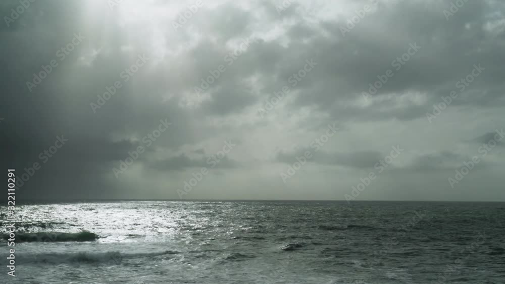 View of the stormy sea. Dramatic sky. Sunlight breaks through the clouds. Watching the storm. Severe raging sea. Big waves. Windy rainy weather. View of the dramatic ocean. View of the stormy sea. Dramatic sky. Sunlight breaks through the clouds. Watching the storm. Severe raging sea. Big waves. Windy rainy weather. View of the dramatic ocean.