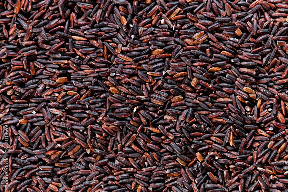 Black wild rice close-up background texture top view, selective focus