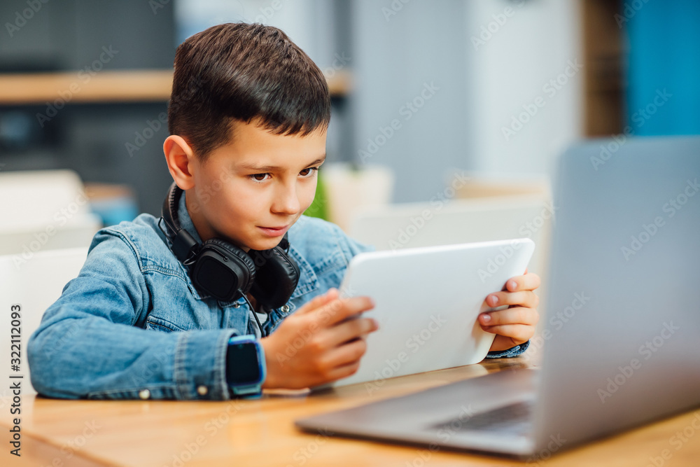Portrait of concentrated boy with laptop doing homework and play games. Portrait of concentrated boy with laptop doing homework and play games.
