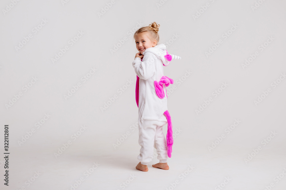 little blonde girl in kigurumi on white background, space for text.modern fashion -children girl posing on a white background in kigurumi pajamas, bunny costume little blonde girl in kigurumi on white background, space for text.modern fashion -children girl posing on a white background in kigurumi pajamas, bunny costume