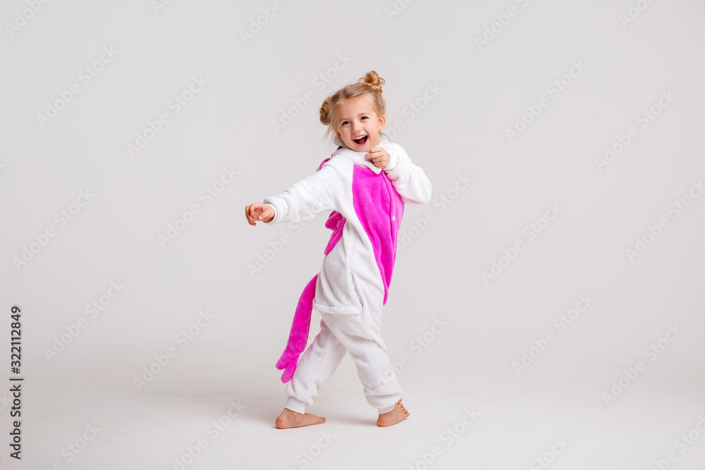 little blonde girl in kigurumi on white background, space for text.modern fashion -children girl posing on a white background in kigurumi pajamas, bunny costume little blonde girl in kigurumi on white background, space for text.modern fashion -children girl posing on a white background in kigurumi pajamas, bunny costume
