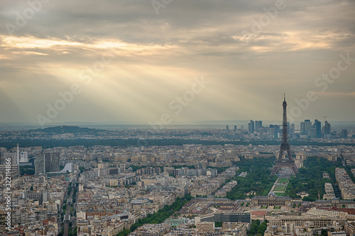Aerial view of Paris, France. Eiffel tower in overcast sky with light rays. © trialartinf
