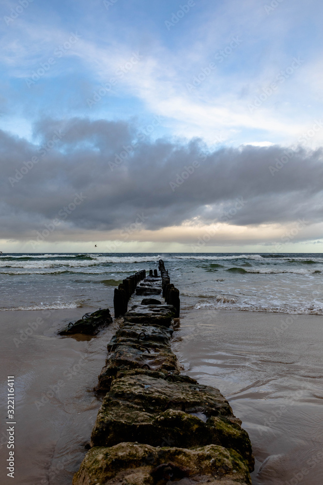 stormy waves crashing against the breakwater against the backdrop of storm clouds stormy waves crashing against the breakwater against the backdrop of storm clouds
