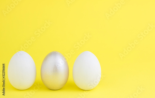 Easter colored bright eggs on a yellow background. Easter creative banner concept card. Copy space