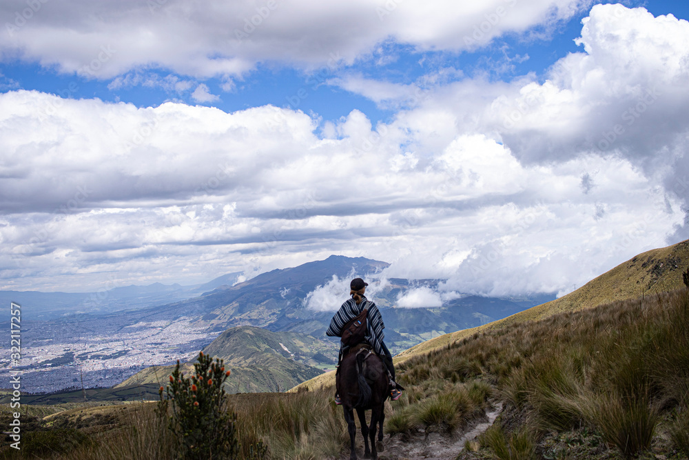 Mujer en caballo con la vista de Quito