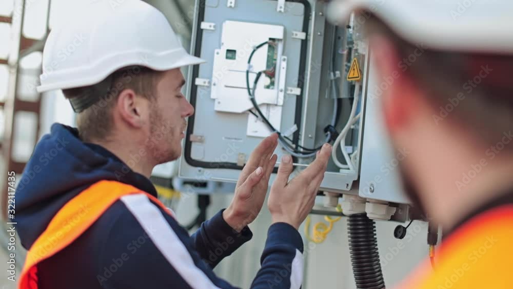 Man working at solar power station. Electrical engineer repairing electricity box at solar power plant Man working at solar power station. Electrical engineer repairing electricity box at solar power plant