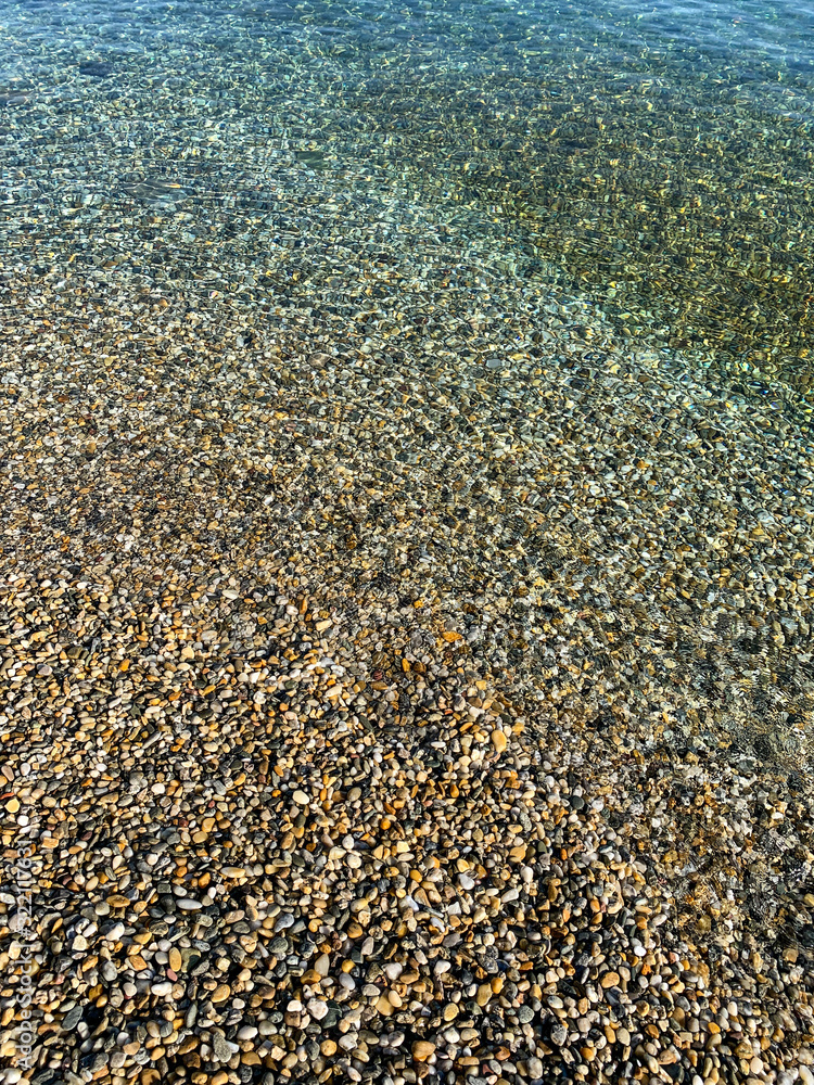 Transparent sea water with pebbles