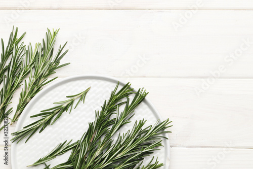 Flat lay composition with fresh rosemary on wooden background  space for text