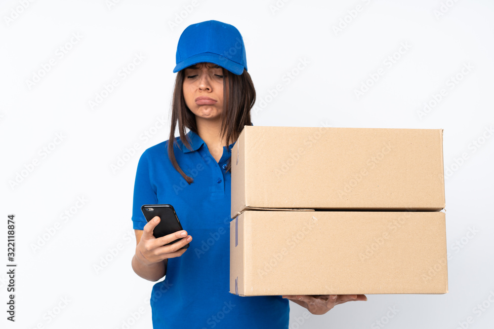 Young delivery brunette girl over isolated white background thinking and sending a message