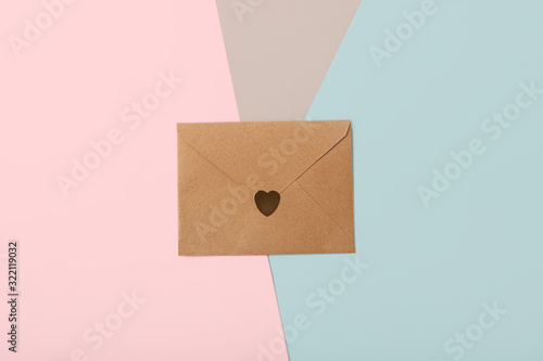 Craft paper envelope on the trendy triple background with golden confetti.Saint Valentines day concept.Love letter.