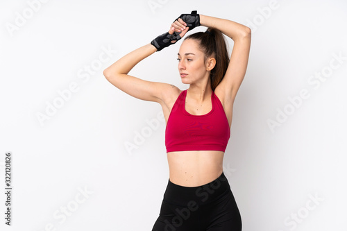 Young sport brunette woman over isolated white background stretching © luismolinero
