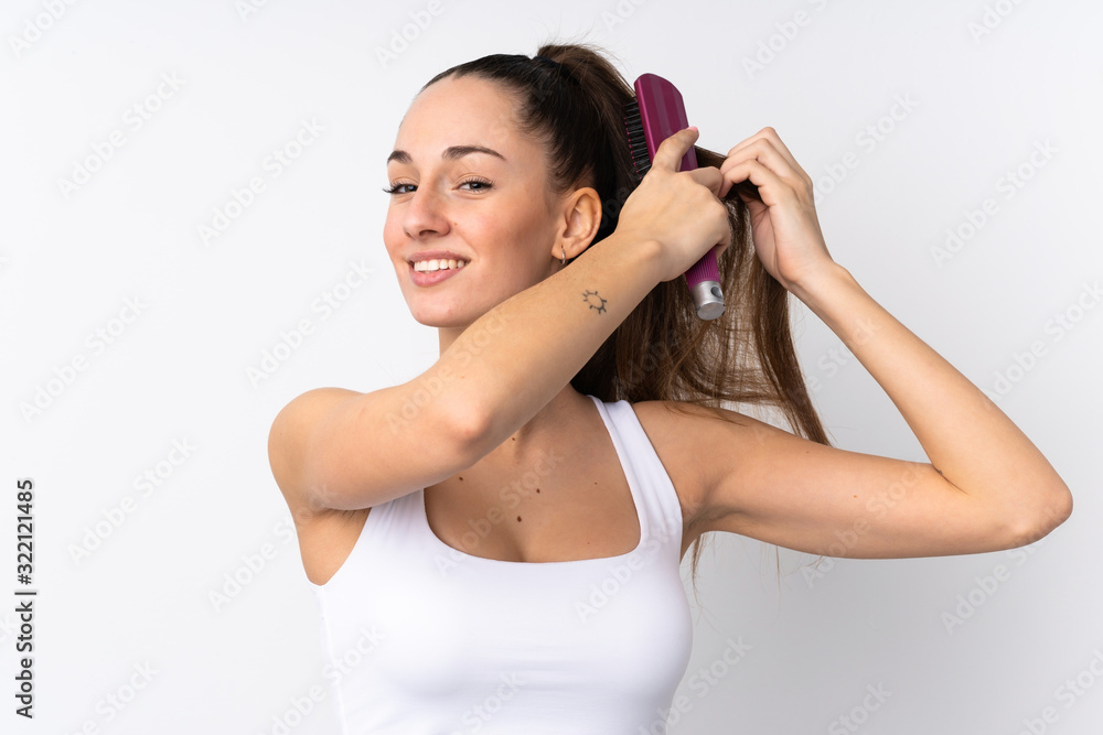 Young brunette woman over isolated white background with hair comb Young brunette woman over isolated white background with hair comb
