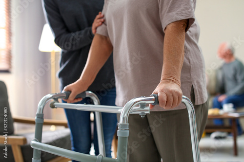 Cuadro en lienzo Care worker helping to elderly woman with walker in geriatric hospice, closeup