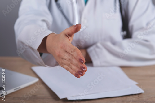 female doctor with open hand ready for handshakes © Alla