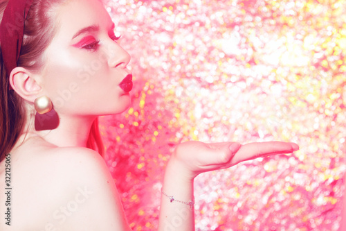 Fototapeta Naklejka Na Ścianę i Meble -  Gorgeous blonde on a bright bokeh background. Girl with pink makeup, in the style of 20x 60s. Girl on a pink background, art photo. Disco girl at the party.