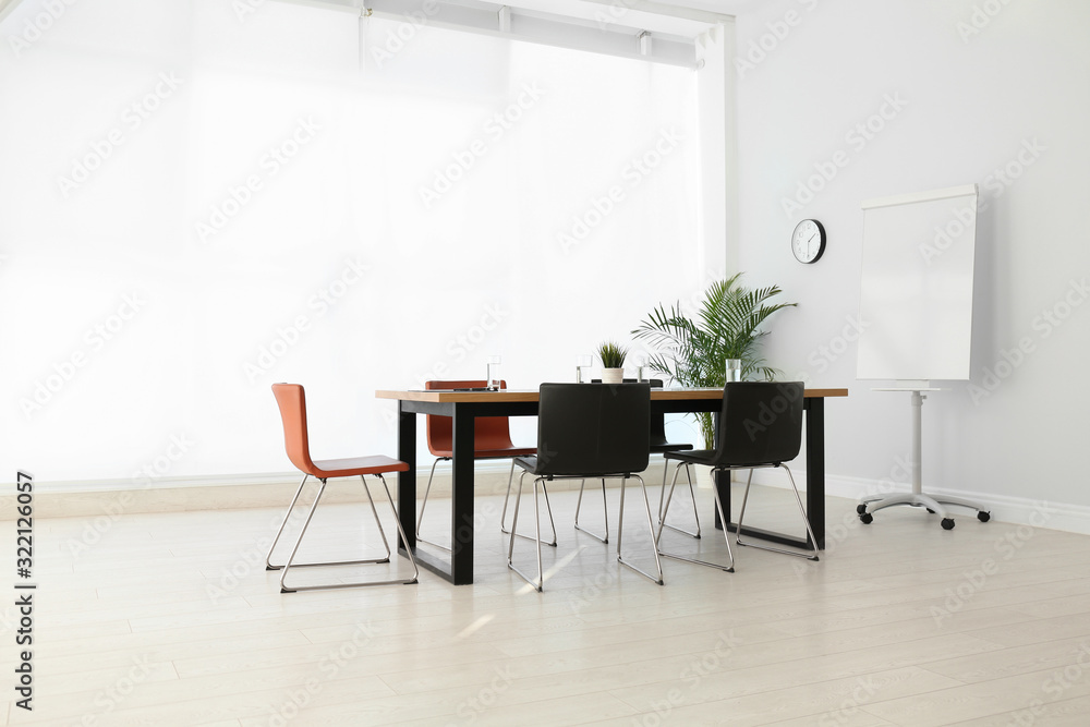 Fototapeta premium Simple office interior with large table and chairs