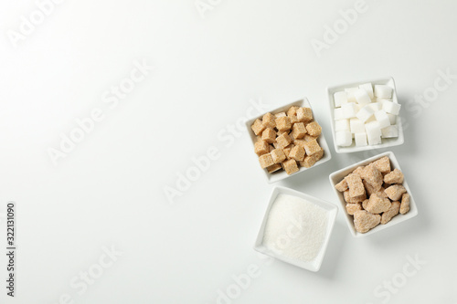 Square bowls with sugar on white background, top view