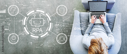 Robotic process automation concept with man using a laptop in a modern gray chair