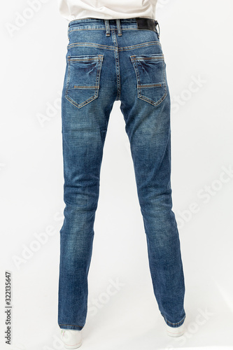 girl in jeans shows off jeans on white background close up, blue jeans