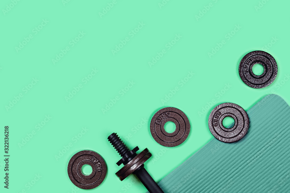 Sports picture. Dumbbells located on sports mat on mint green background. Flat lay, top view, copy space. - obrazy, fototapety, plakaty 