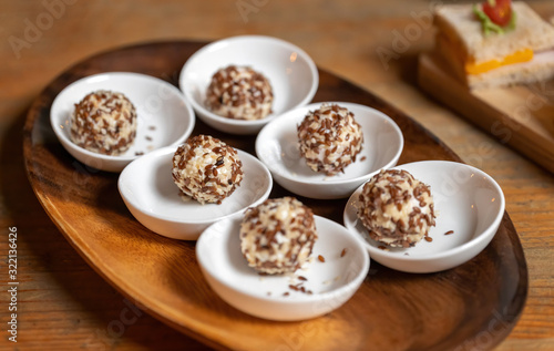 Cream cheese balls coated with white and brown sesame seeds. Tasty treat.