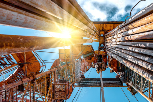 Oil and Gas Drilling Rig onshore dessert with dramatic cloudscape. Oil drilling rig operation on the oil platform in oil and gas industry