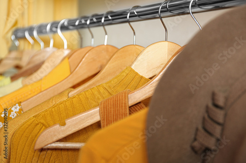 Different styling clothes on wooden hangers in wardrobe, closeup. Fashion blogger © New Africa