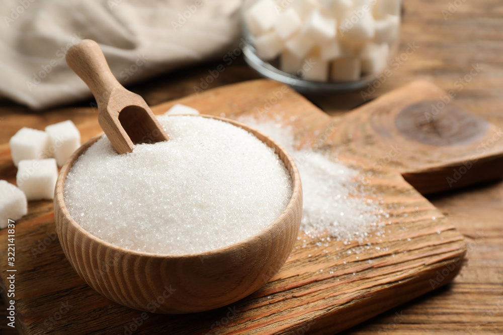 Granulated sugar in bowl on wooden table Granulated sugar in bowl on wooden table